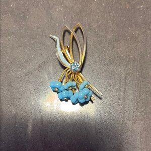 Vintage Austrian floral brooch gold tone with one blue rhinestone